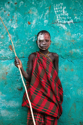 Portrait of a Suri Boy Against a Green Wall by John Rowe