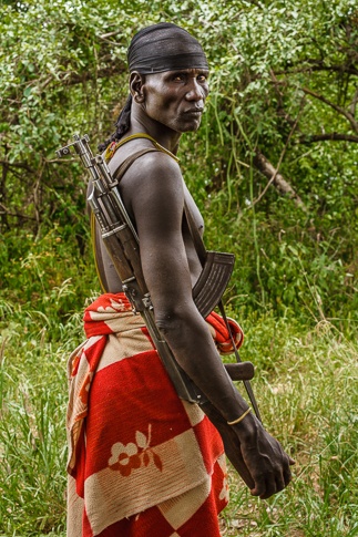 Portrait of a Mursi man with AK-47 by John Rowe